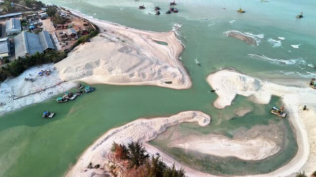 coastal tin mining activity in jelitik bangka estuary showing sediment formations, traditional vessels and changing shoreline landscape