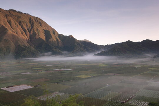 Misty agricultural valley and mountain landscape viewed from Bukit Selong, Sembalun, East Lombok, Indonesia.