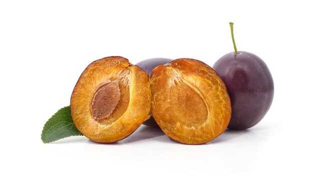 Fresh purple plums whole and cut in half isolated on a white background.