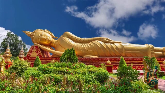 Reclining Buddha statue outside temple next to the iconic Pha That Luang stupa in Vientiane, Laos.Laos Golden Reclining Buddha adjacent to Pha That Luang in Vientiane, Laos