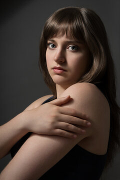 Portrait of a beautiful teenage girl posing on a dark background for beauty concept