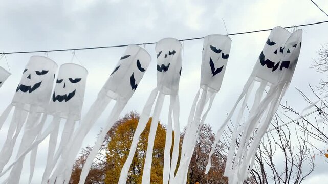 Spooky scary ghosts monster faces lanterns waving on wind on halloween background,autumn holidays,decoration and party concept