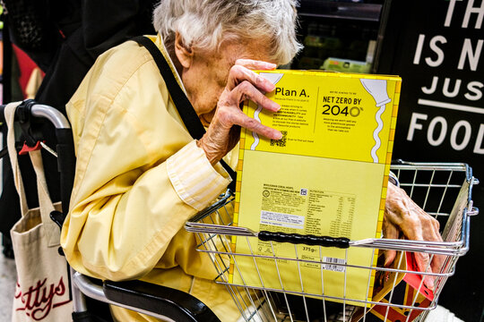 Unrecognisable Elderly Woman In Wheelchair Holding A Cereal Box Showing Plan A Net Zero 2040 Message