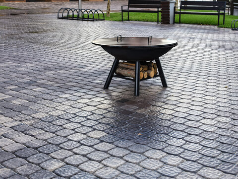Close Up of Metal Outdoor Fire Pit on Paved Ground