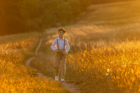 Sweet preteen child, boy, playing in a field on sunset with kite and old vingate car, walking with grandmother in the countryside
