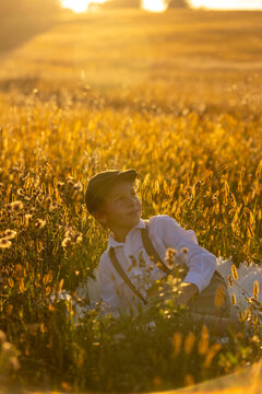 Sweet preteen child, boy, playing in a field on sunset with kite and old vingate car, walking with grandmother in the countryside
