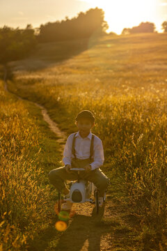 Sweet preteen child, boy, playing in a field on sunset with kite and old vingate car, walking with grandmother in the countryside