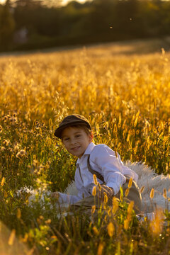 Sweet preteen child, boy, playing in a field on sunset with kite and old vingate car, walking with grandmother in the countryside