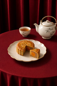 Traditional baked mooncake with egg cake on red table