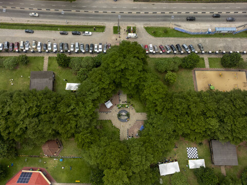 Aerial view of Ndubuisi Kanu Park featuring lush green trees, paved walkways, a central fountain area, and adjacent parking lots with cars in Ikeja, Lagos, Nigeria.