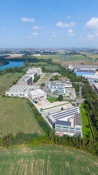 Aerial view of chemical laboratory and telecommunications company facilities in an industrial area, with modern buildings and specialized infrastructure. Milan, Lombardy, Italy.