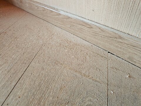 Dirt and dust accumulation on floor near wall in indoor