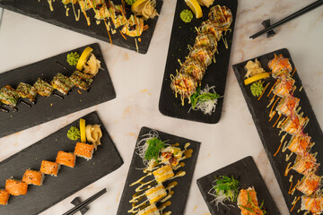 Assorted gourmet sushi platter set with various sushi rolls served on black slate boards, top-down view © Curtis.at 