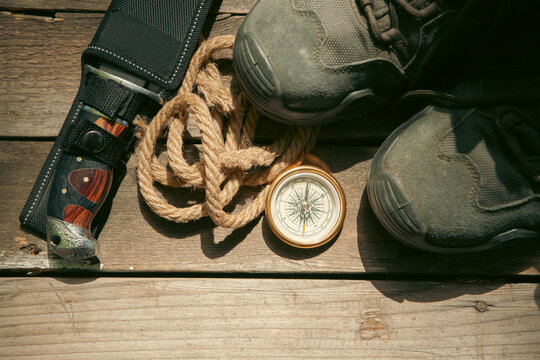 Compass, boots and rope on a wooden background. Toned.
