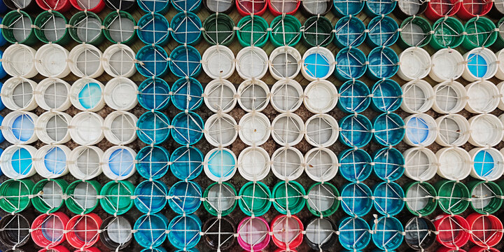 Reusing plastic bottle caps in various colors, creating a vibrant pattern for sustainability and environmental protection