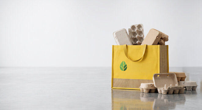 Yellow reusable bag with egg cartons on reflective surface