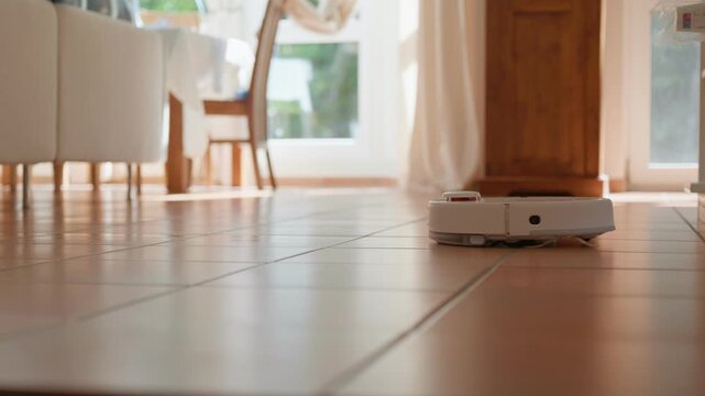 Robot vacuum cleaning a home vacuums and mops the brown tile floor low angle