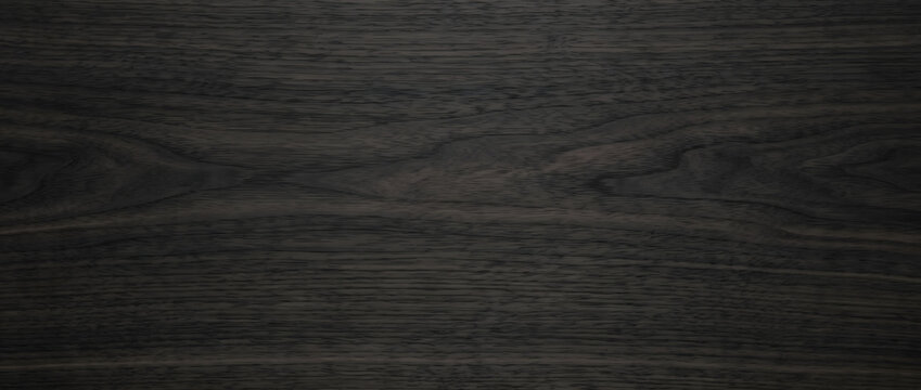 Black ebony wood texture background with subtle cathedral grain and matte dark finish for modern furniture design