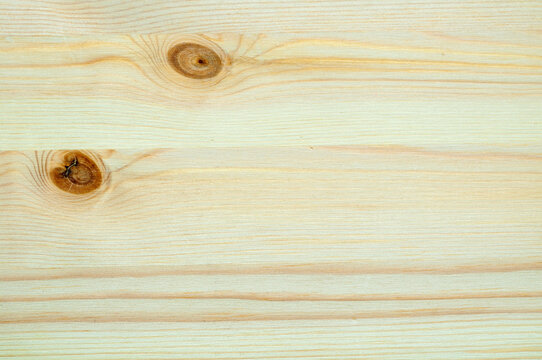 Pale wood texture background. Knotty pine planks with wavy horizontal grain. Distinct brown knots and a soft natural timber surface for carpentry work