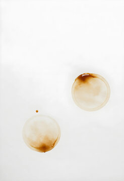 Coffee stains on paper, morning routine and office mess concept, accidental spill marks from a mug on a clean white background for design texture