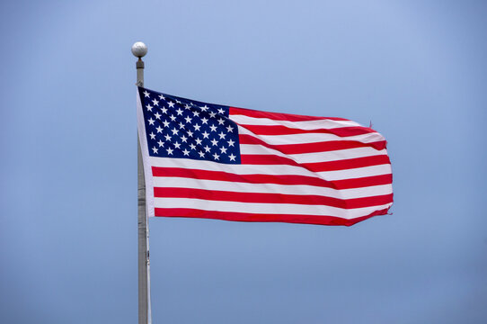 American flag waving against a clear blue sky