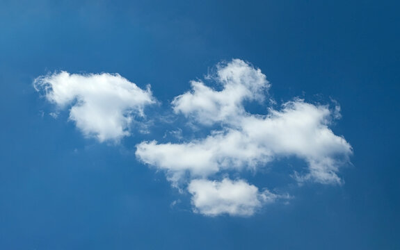 A composite cloud of several wisps of rolling vapor. Wind flow forms a rain clouds that accumulates to the required critical mass. Beautiful seascape natural composition simple blue sky with steam.