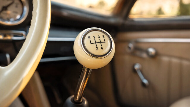 Manual gear shifter in a vintage car interior with ivory knob