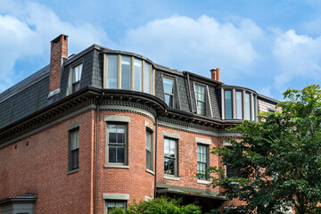 Decorative brick facade with bay windows and mansard roof in Boston, Massachusetts © Baharlou