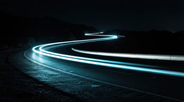 Long exposure light trails on a winding mountain road at night
