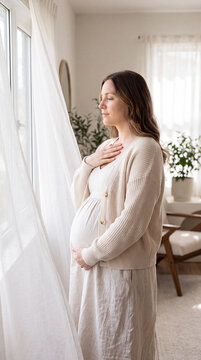 Pregnant woman meditates peacefully by a sunlit window in a softly-lit room. She embraces serenity and mindfulness, radiating calm and contentment. Image made using Generative AI.