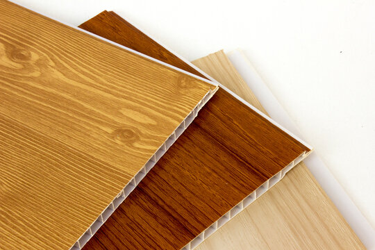 A closeup photo of  PVC wall panel samples with different wood grain textures on white background