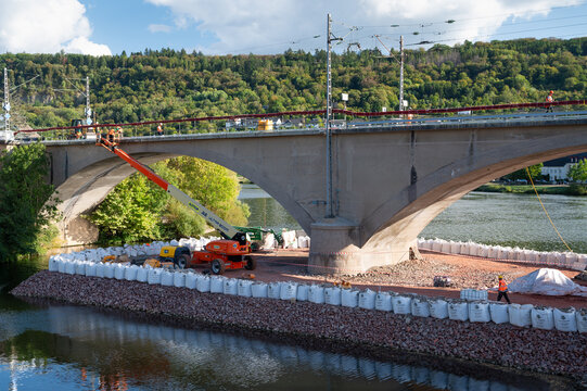 Construction site railway bridge Wasserbillig, Luxembourg, excavators and road roller, temporary bank reinforcement, sandbags and crushed stone