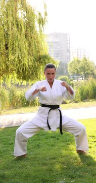 Self-defense. Young woman practicing martial arts in park