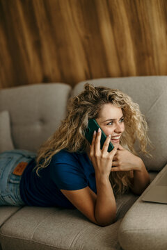 Young woman smiling while talking on phone at home