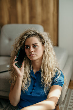 Woman listening intently on her mobile phone indoors