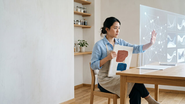 自分の絵を抱えて人工知能の投影画面を押し返す女性