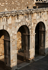Obraz premium Historical architecture and heritage preservation, ancient stone arches and masonry walls in a classic Mediterranean courtyard at sunset light