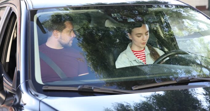 Driving school. Instructor and student fastening seat belts in car
