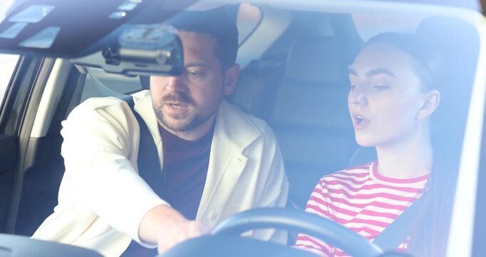 Woman having driving lesson with instructor in car
