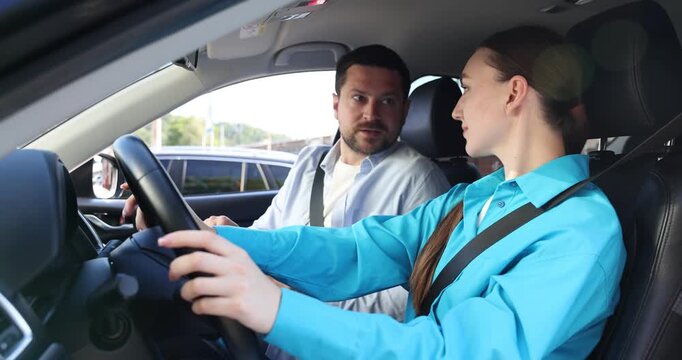 Woman having driving lesson with instructor in car