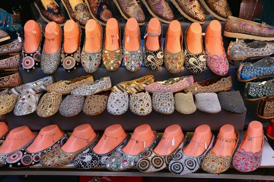 Dubai fashion marketplace with women's shoes. Jutti shoes typical for India and Pakistan, decorated with pearls, beads, and sequins. They have matching anklets (pazaib or payal).