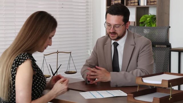 Lawyer working with client at table in office. Camera moving forward