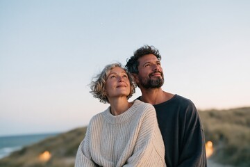 Naklejka premium Romantic mature couple gazing at sunset by the sea for lifestyle background and romantic banner design