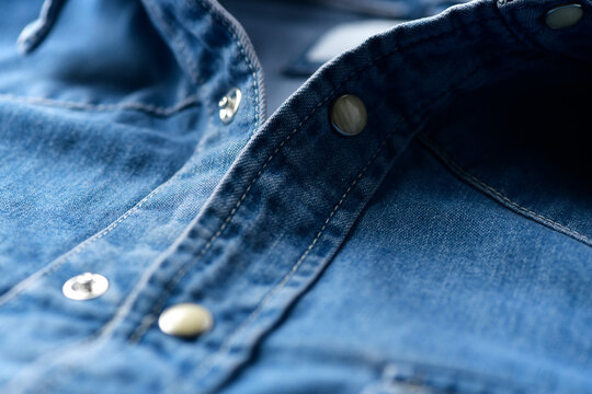Close up of blue denim shirt with buttons. Soft focus. 