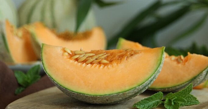 Woman putting piece of Cantaloupe melon on wooden table, closeup