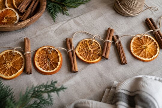 Dried orange garland and cinnamon on a linen background