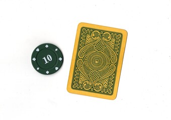 A vintage playing card and poker chip isolated on a white background. © Philip