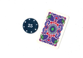 A vintage playing card and poker chip isolated on a white background. © Philip
