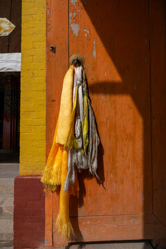 Yellow and white silk scarves hang from a door at Shachong monastery, Qinghai Province, Wayaotai, China