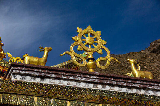 Golden Dharma wheel and deer statues on a monastery rooftop, Tongren County, Longwu, China